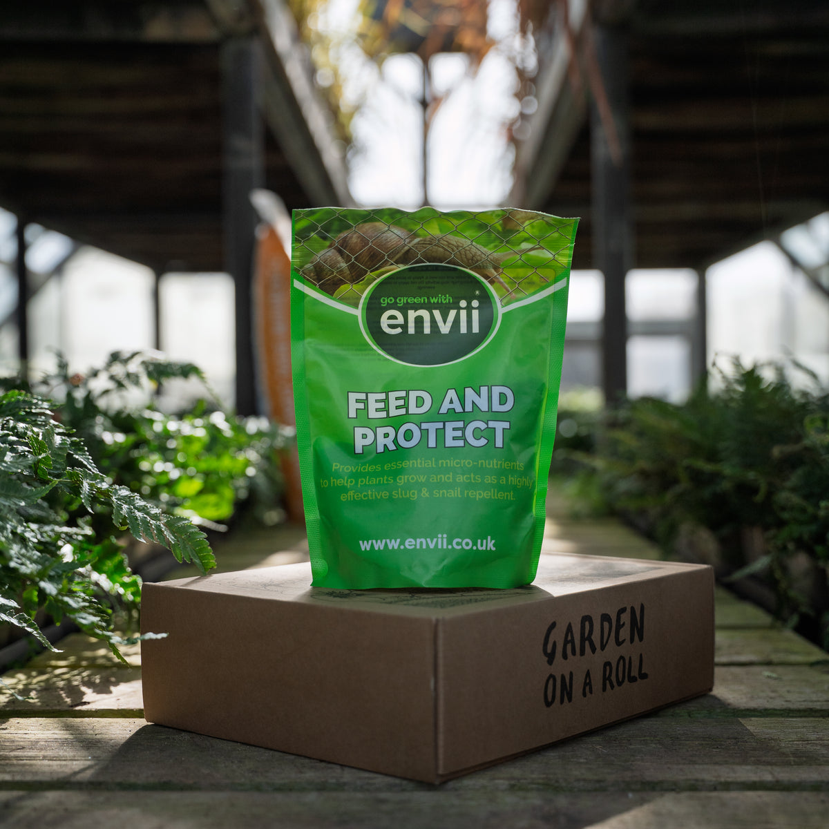 Envii Feed and Protect plant food and slug and snail repellent displayed with a Garden on a Roll border box.